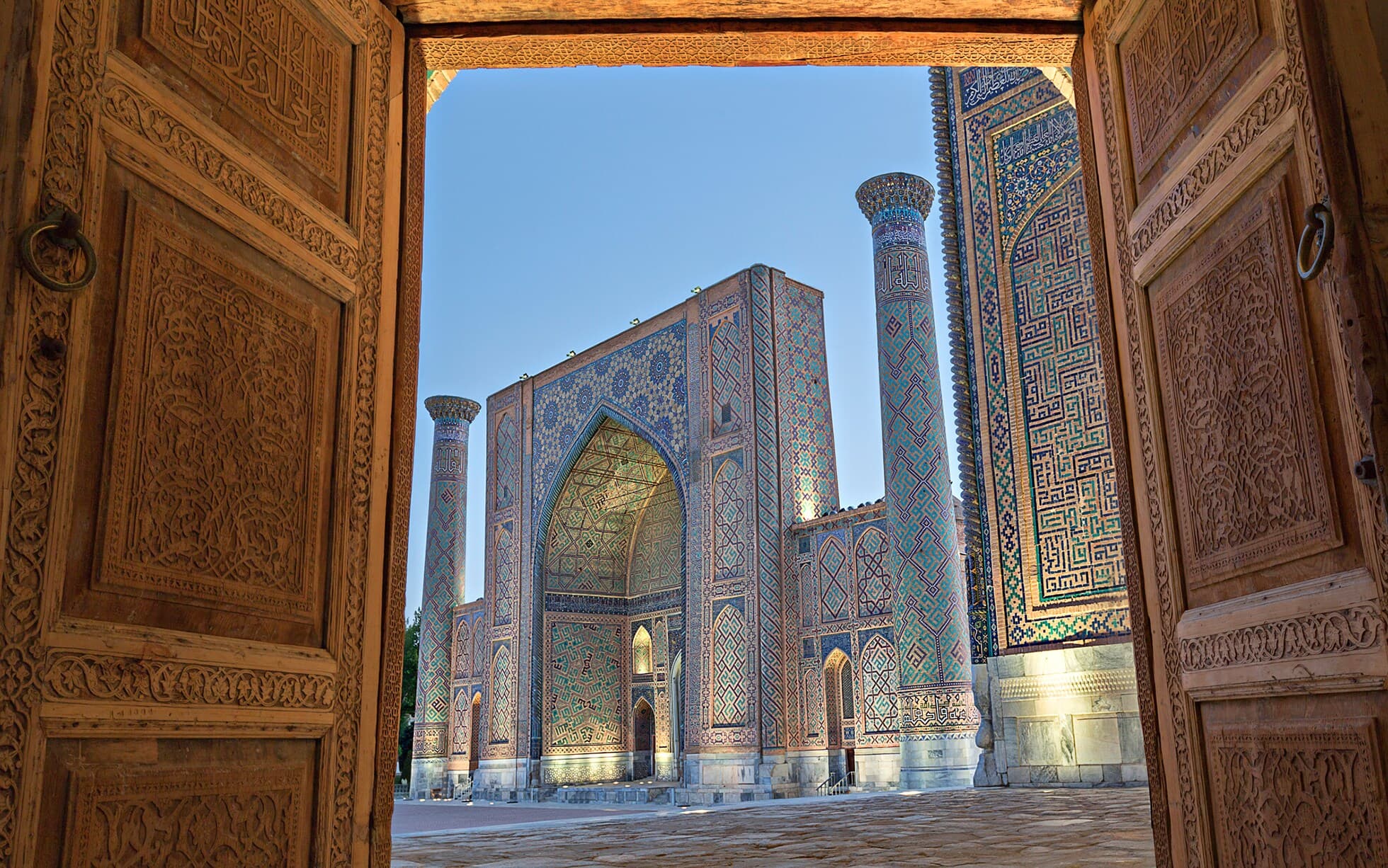 Panoramic view of the ancient Silk Road in Central Asia, showcasing snow-capped mountains, historical caravan routes, and traditional architectural landmarks of the region